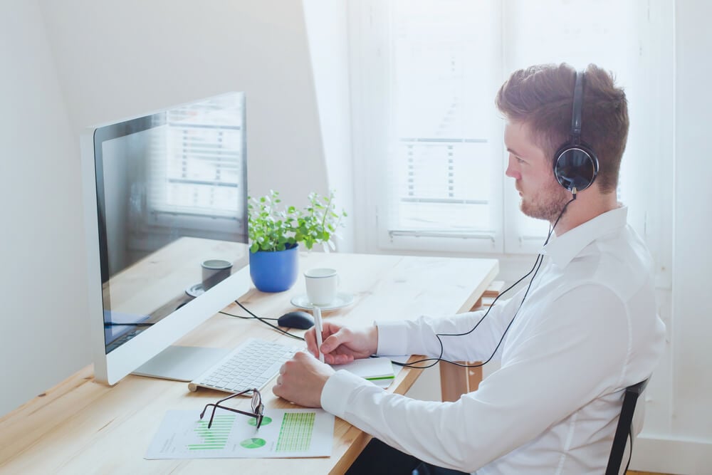 homem concentrado acessando o computador com fones de ouvido