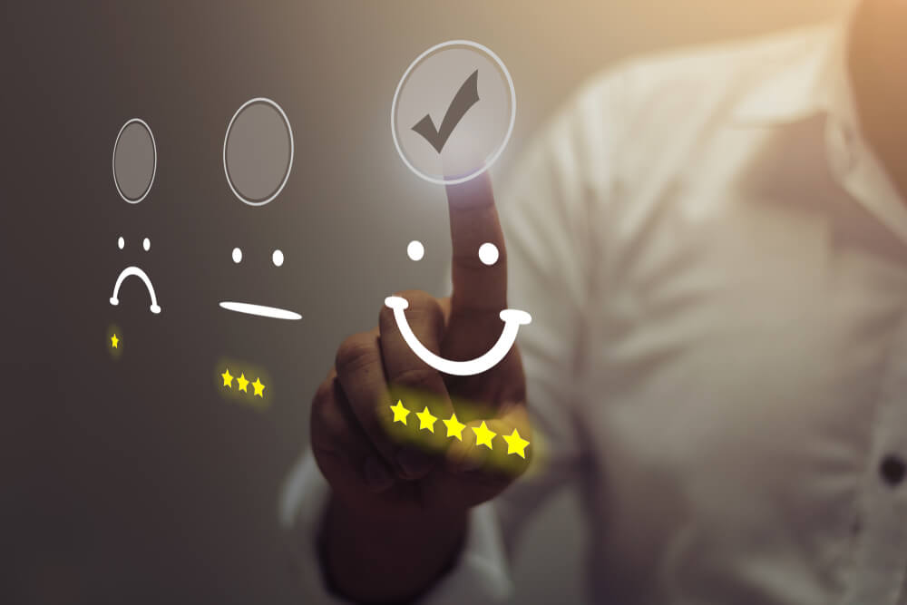 homem selecionando ilustraçao com rosto feliz simbolizando a pesquisa de satisfaçao do cliente