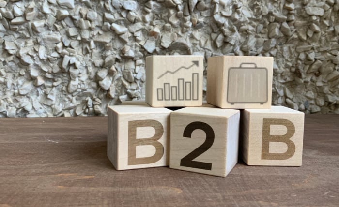 blocos de madeira com a sigla b2b e ícones de parceria e logística, simbolizando relações comerciais entre empresas.