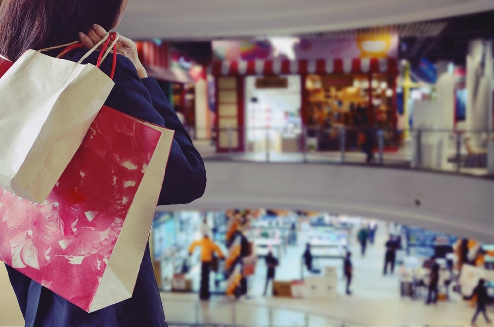 consumidor segurando sacola de compras loja física