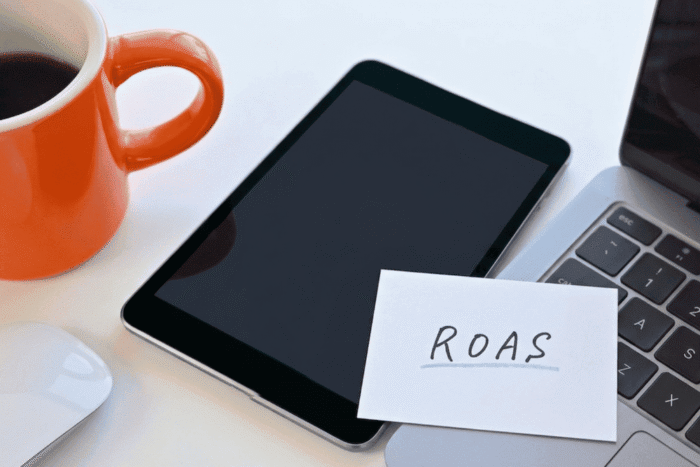 Um tablet e um notbook em cimad e uma mesa e um papel escrito ROAs